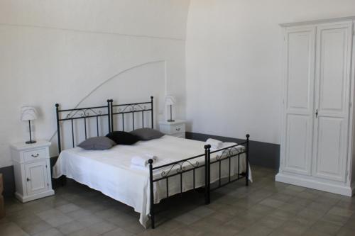 a bedroom with a bed and two night stands and two lamps at Tenuta Orsanese in Ginosa Marina
