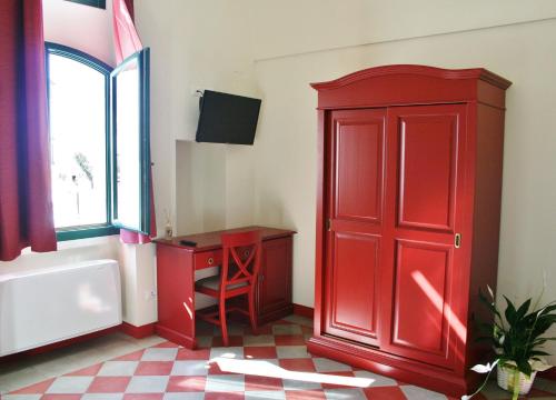 a bathroom with a red door and a red cabinet at Tenuta Orsanese in Ginosa Marina