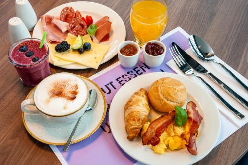 a table with plates of breakfast food and a cup of coffee at ibis Styles St Margrethen Bodensee in Sankt Margrethen