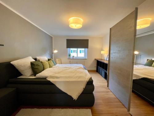 1 dormitorio con cama y espejo en Ferienwohnung Böhlen im Leipziger Neuseenland en Böhlen