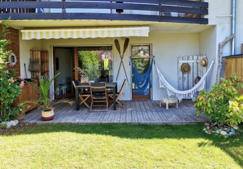 a patio with a table and chairs in a yard at ** Nouveau ** Le Jardin De La Plage - Appartement avec extérieur in Saint-Jorioz