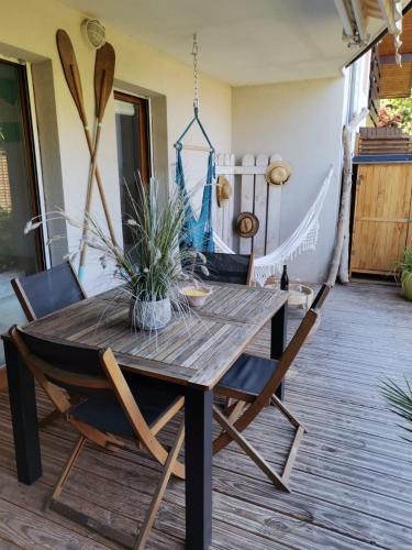 a wooden table and chairs on a patio at ** Nouveau ** Le Jardin De La Plage - Appartement avec extérieur in Saint-Jorioz