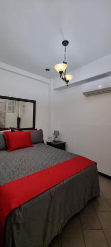 a bedroom with a large bed with a red blanket at Cayalito Apart Hotel in Guatemala