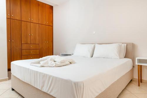 a bedroom with a large white bed with wooden cabinets at Naxos Almyra Apartment 22 in Naxos Chora