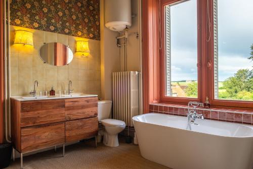 baño con bañera, aseo y ventana en Château Le Boisrenault, en Buzançais