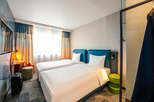 a hotel room with a large bed and a window at ibis Styles St Margrethen Bodensee in Sankt Margrethen