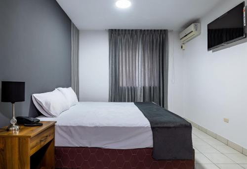a hotel room with a bed and a television at Hotel Taurus in Piura