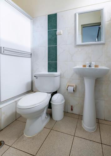 a bathroom with a toilet and a sink at Hotel Taurus in Piura