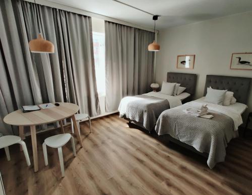 um quarto de hotel com duas camas e uma mesa em Hotel Homeland em Tampere