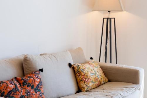 - un canapé blanc avec deux oreillers et une lampe dans l'établissement Résidence Domaine d'Arca Porto Vecchio - Location T2 - 4 personnes 