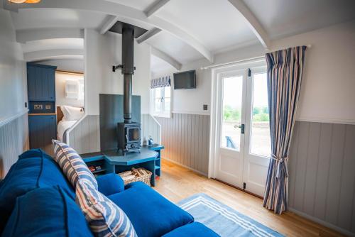 a living room with a blue couch and a window at Inglewood Shepherd's Huts in Penrith