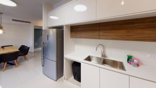a kitchen with a stainless steel refrigerator and a table at Luxury apartments Boutique Haneviim in Jerusalem