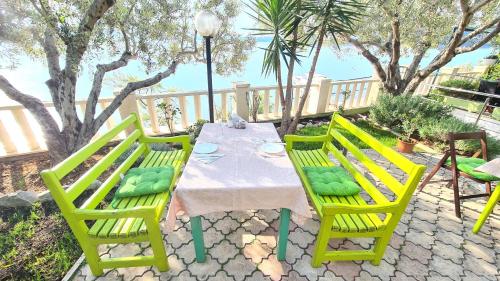 ein Tisch mit gelben Stühlen und ein Tisch mit einer weißen Tischdecke in der Unterkunft Apartments G in Trogir