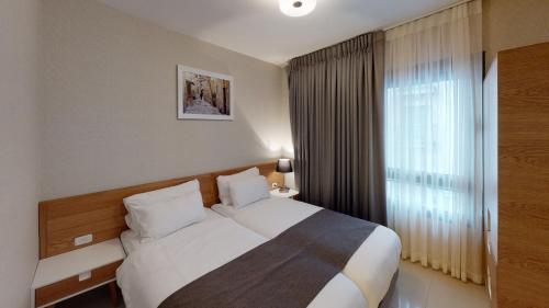 a hotel room with a bed and a window at Luxury apartments Boutique Haneviim in Jerusalem
