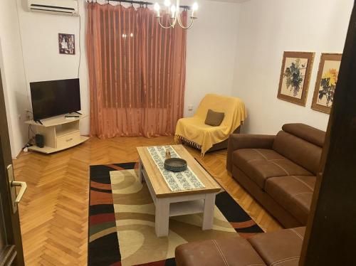 - un salon avec un canapé et une table dans l'établissement Seljanovo 77m2, à Tivat