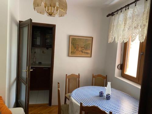 une salle à manger dotée d'une table avec un chiffon de table bleu et blanc dans l'établissement Seljanovo 77m2, à Tivat