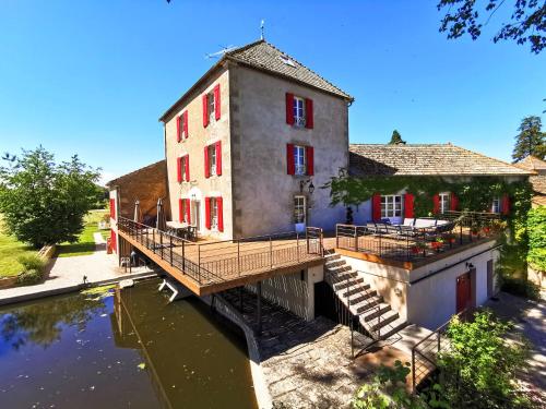 a building with a bridge over a body of water at Le Moulin des Ducs in Épinac-les-Mines