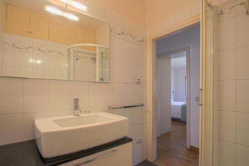 a white bathroom with a sink and a mirror at Giorgio Ponte Vecchio Apartment in Florence