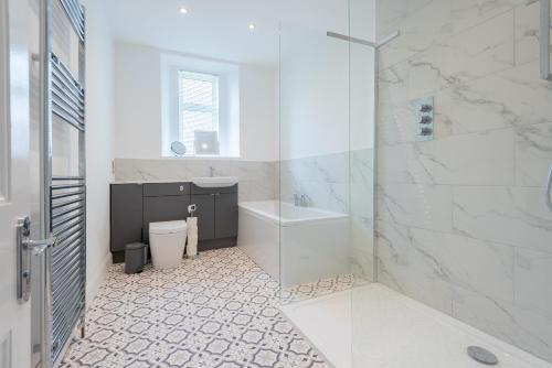 a bathroom with a shower and a toilet and a sink at River View Apartment in Dundee