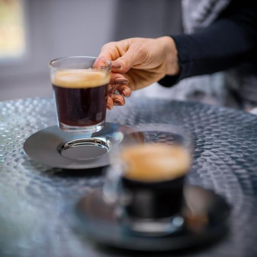 a person holding a cup of coffee on a table at Apartmány Dačický 2 in Kutná Hora