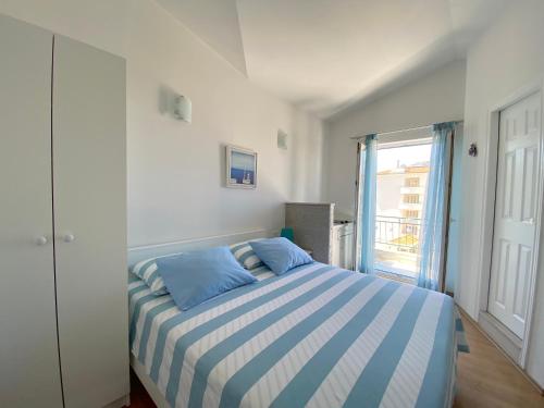 a bedroom with a bed with blue and white stripes at Apartmani Marko in Tučepi