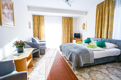 a bedroom with a bed and a couch and a table at Villa Nadmorska Łeba Centrum in Łeba