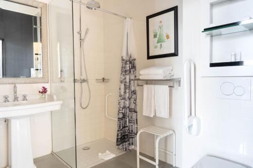La salle de bains est pourvue d'une douche et d'un lavabo. dans l'établissement Le 123 Elysees - Astotel, à Paris