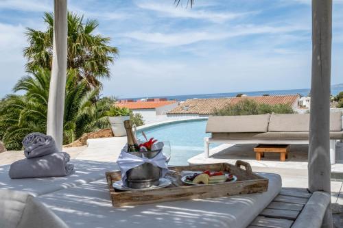 a table with a tray of food on it next to a pool at El Cortijo de Zahara by QHotels in Zahara de los Atunes