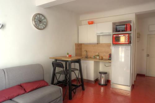 a kitchen with a couch and a table in a room at Studio au cœur du village provençale de Riez. Dans le Verdon. in Riez