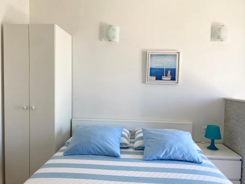 a bedroom with a bed with blue pillows at Apartmani Marko in Tučepi