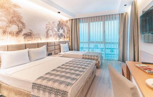 a hotel room with two beds and a table at PEARLY HOTEL in Antalya