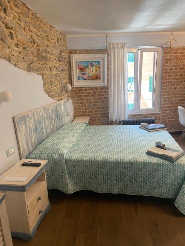1 dormitorio con cama y pared de ladrillo en Cà Della Valletta, en Riomaggiore