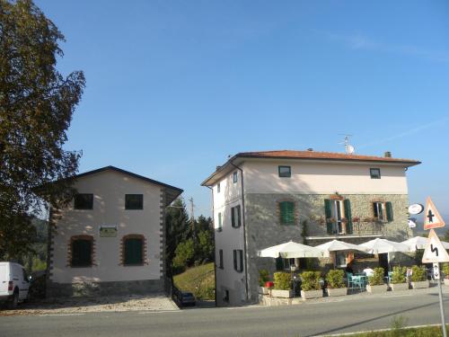 a white building next to a building with umbrellas at La Castagna Matta in Albareto