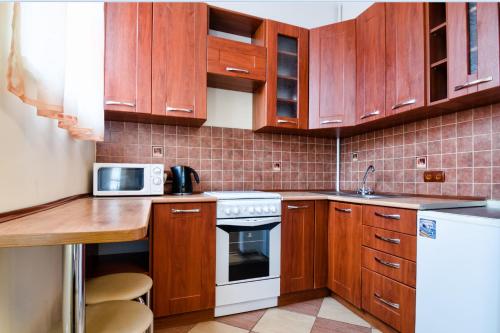 リヴィウにあるLEOGRAND Apartments on Kniazia Romana 26のキッチン(木製キャビネット、白いコンロ付)