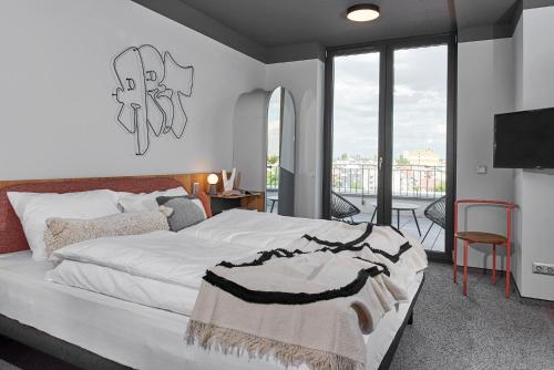 a bedroom with a large bed and a balcony at SmartApart in Budapest