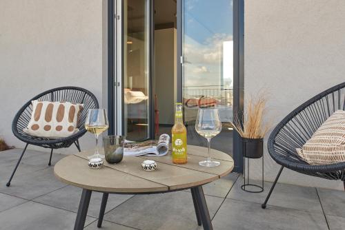 a table with two glasses and a bottle of wine at SmartApart in Budapest