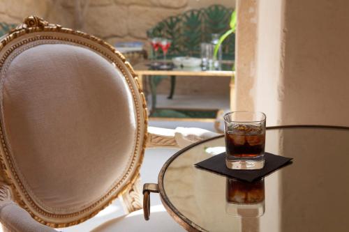 a glass of tea on a table next to a chair at Relais Fra' Lorenzo in Verona