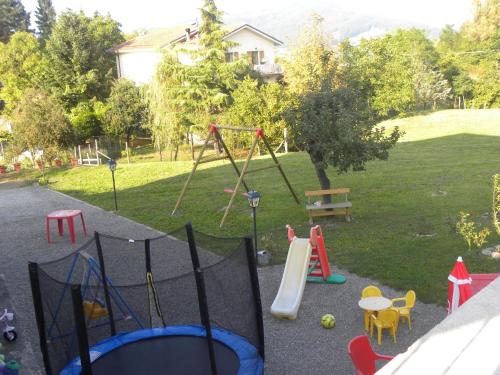 a playground with a slide and a swing set at La Castagna Matta in Albareto