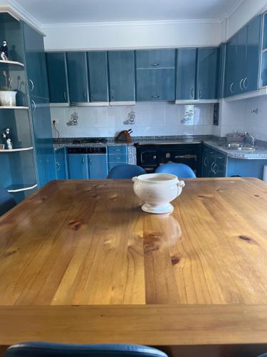 a wooden table in a kitchen with a bowl on it at Casa Las Piedras in Padrenda