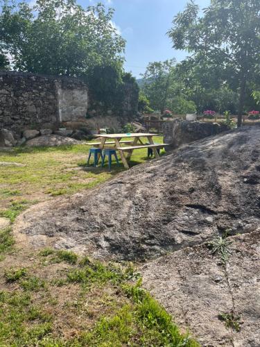 a wooden picnic table sitting on top of a field at Casa Las Piedras in Padrenda