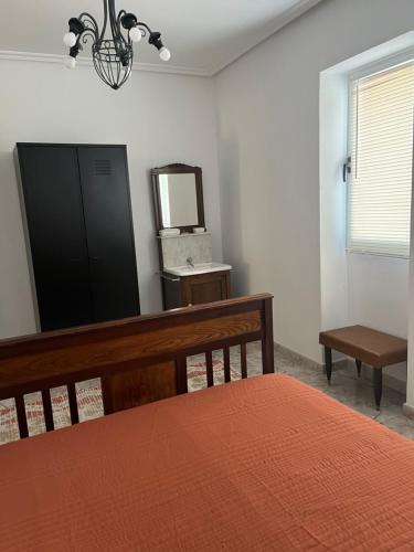 a bedroom with a bed and a mirror and a bench at Casa Las Piedras in Padrenda