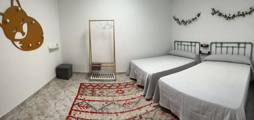 a room with two beds and a rug at Casa Las Piedras in Padrenda