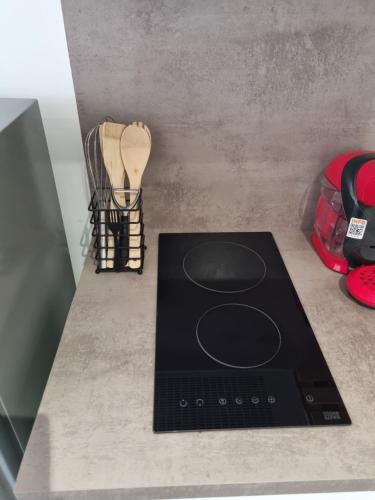 uma placa de fogão num balcão ao lado de uma guitarra em Logement chaleureux 2 personnes em Saint-Gaudens