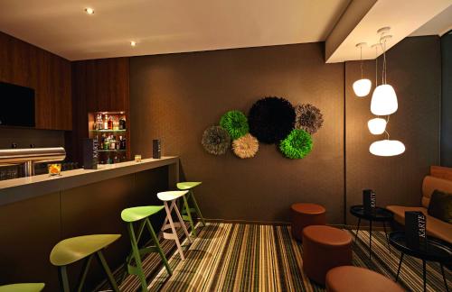 a restaurant with green stools and a bar at Seaside Residenz Hotel Chemnitz in Chemnitz