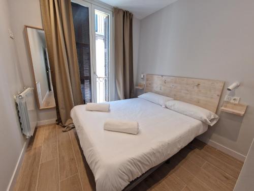 a bedroom with a bed with two pillows on it at Beach Break Guesthouse in Donostia-San Sebastián