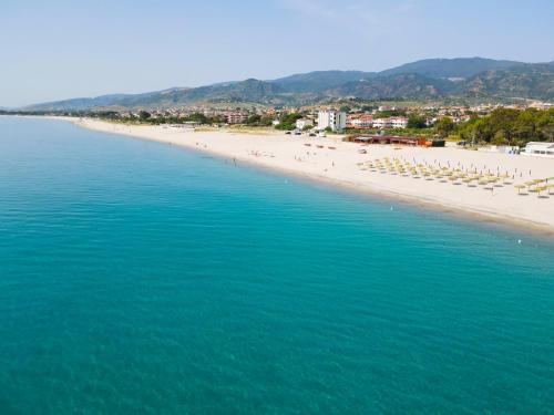 a beach with chairs and umbrellas and people on it at Hotel Rivabella in Davoli