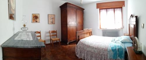 a bedroom with a bed and a dresser and a table at Casa Romme in Tornolo