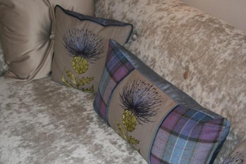 dos almohadas sentadas en la parte superior de un sofá en Grassmarket Studio, en Edimburgo