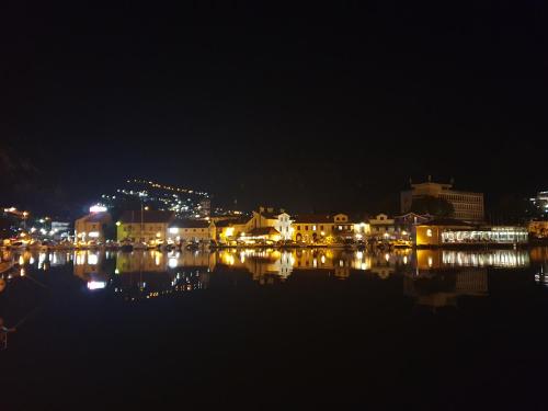 a city lit up at night with a body of water at Kotor Center W in Kotor
