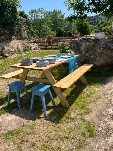 a picnic table and benches with plates and dishes on it at Casa Las Piedras in Padrenda